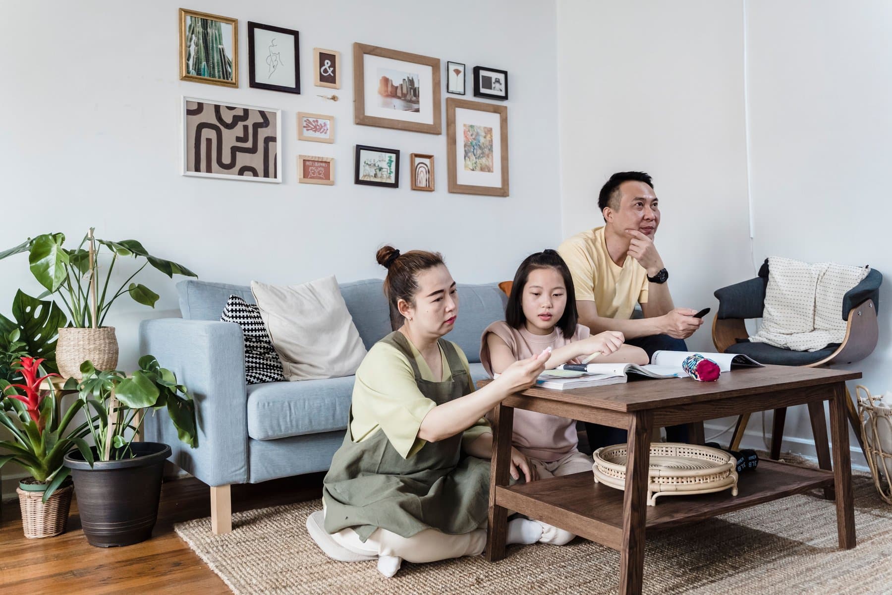 A family spending time together in a living room with a wood floor and jute rug