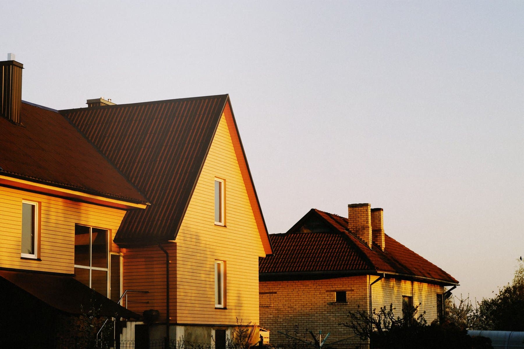 A cottage-style home exterior lit in vivid golden-hour light