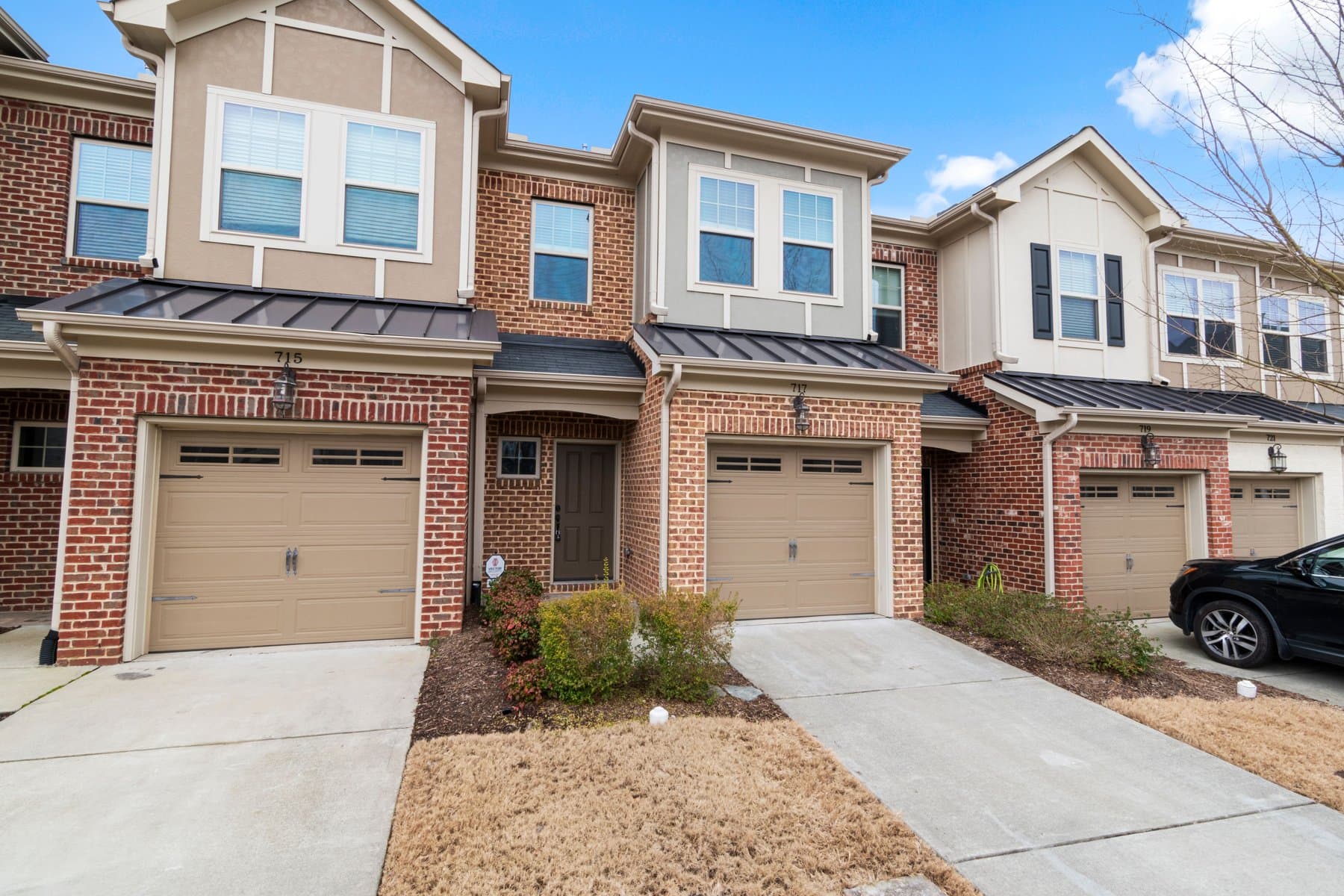 Attached brick townhome exteriors with garages in a suburban setting